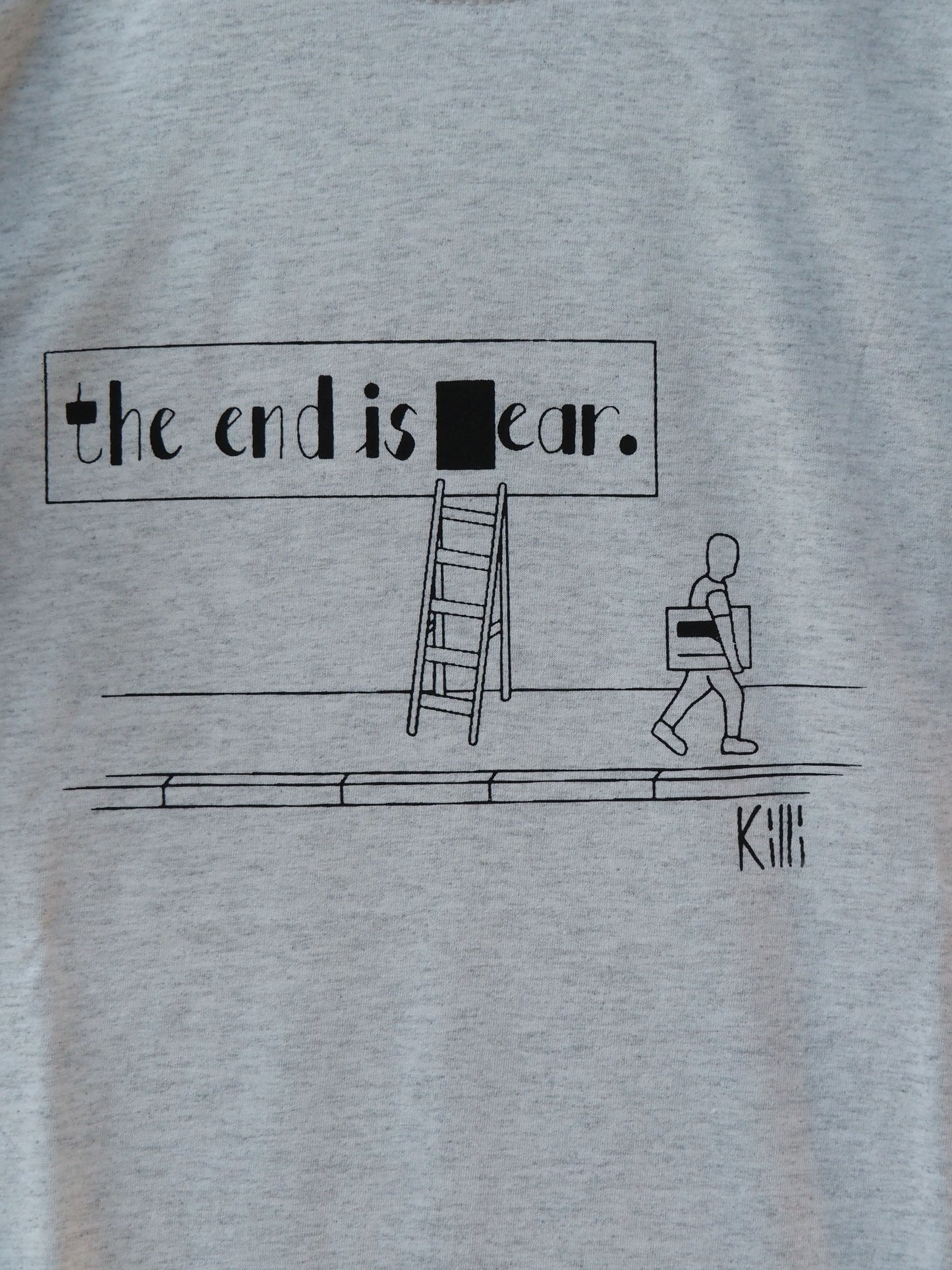 Light gray t-shirt with black graphic and text 'the end is ear' on a plain background