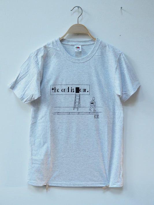 Ash grey t-shirt with a punny graphic design on a hanger against a white wall
