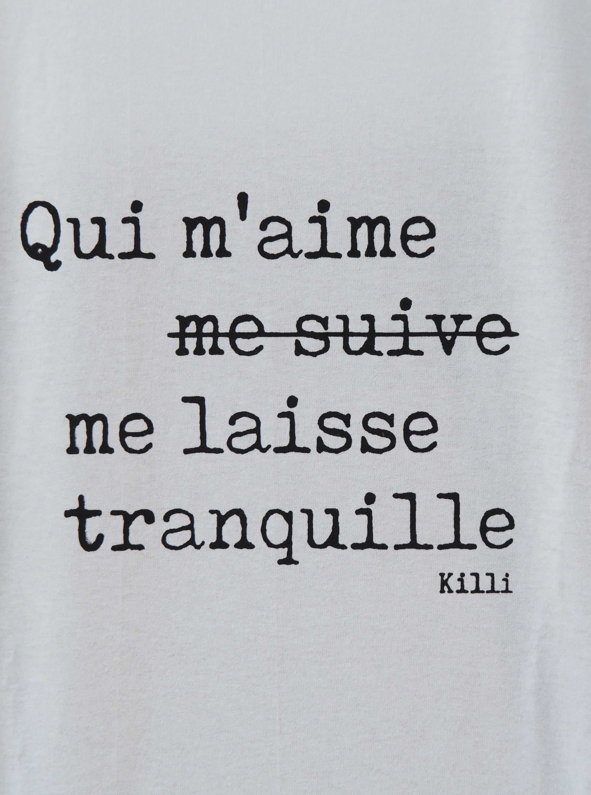 Text on a light gray background with a quote in French.