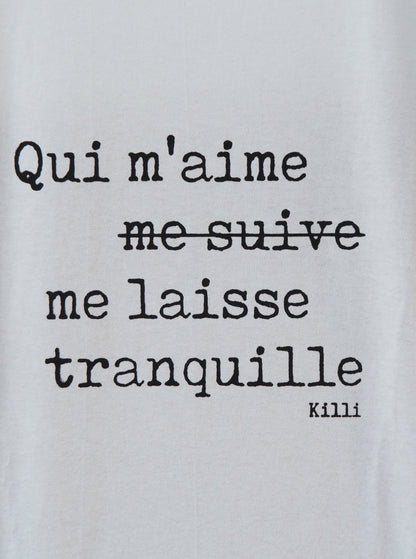 Text on a light gray background with a quote in French.