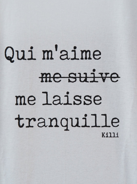 Text on a light gray background with a quote in French.