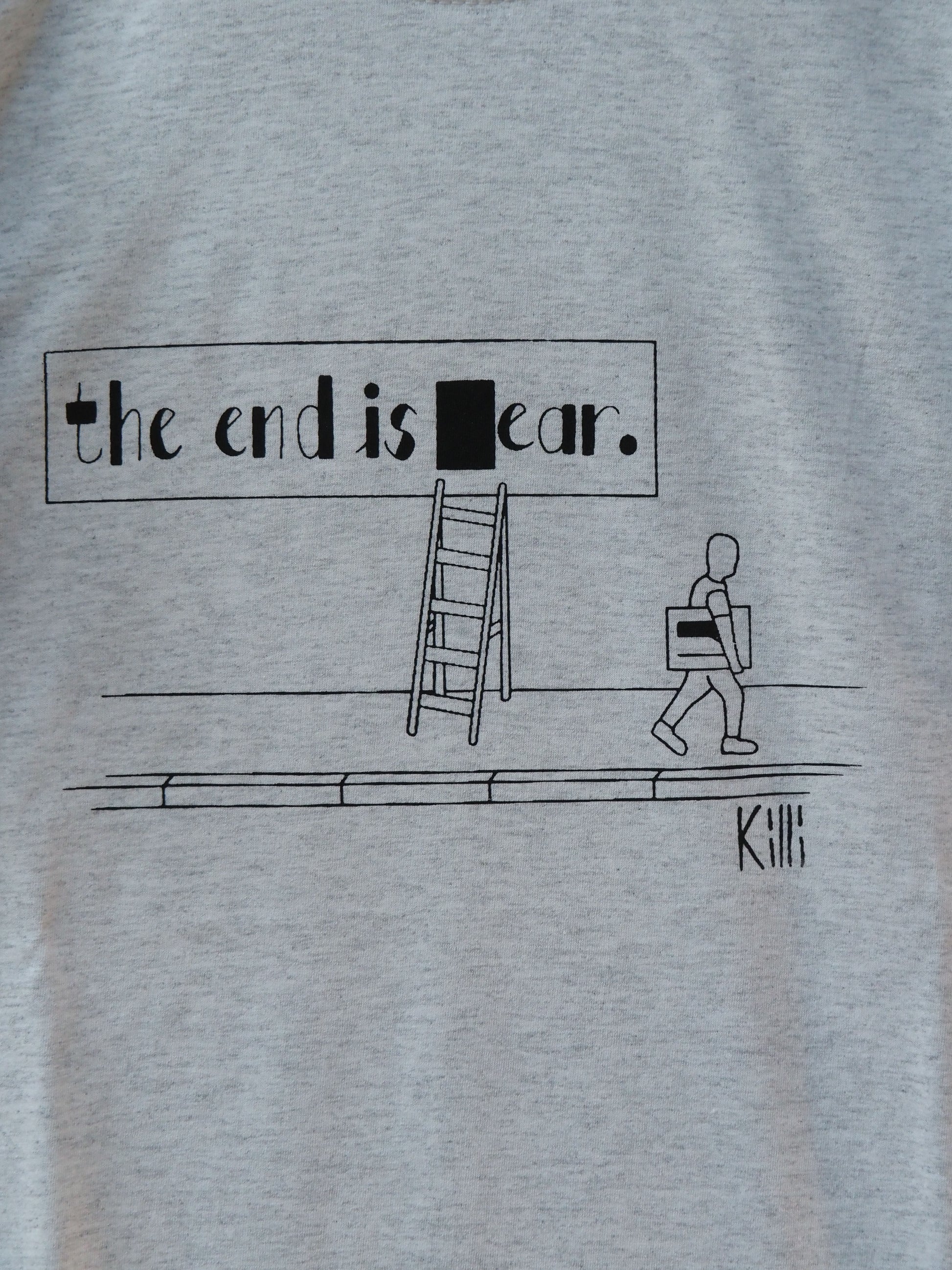 Light gray t-shirt with black graphic and text 'the end is ear' on a plain background