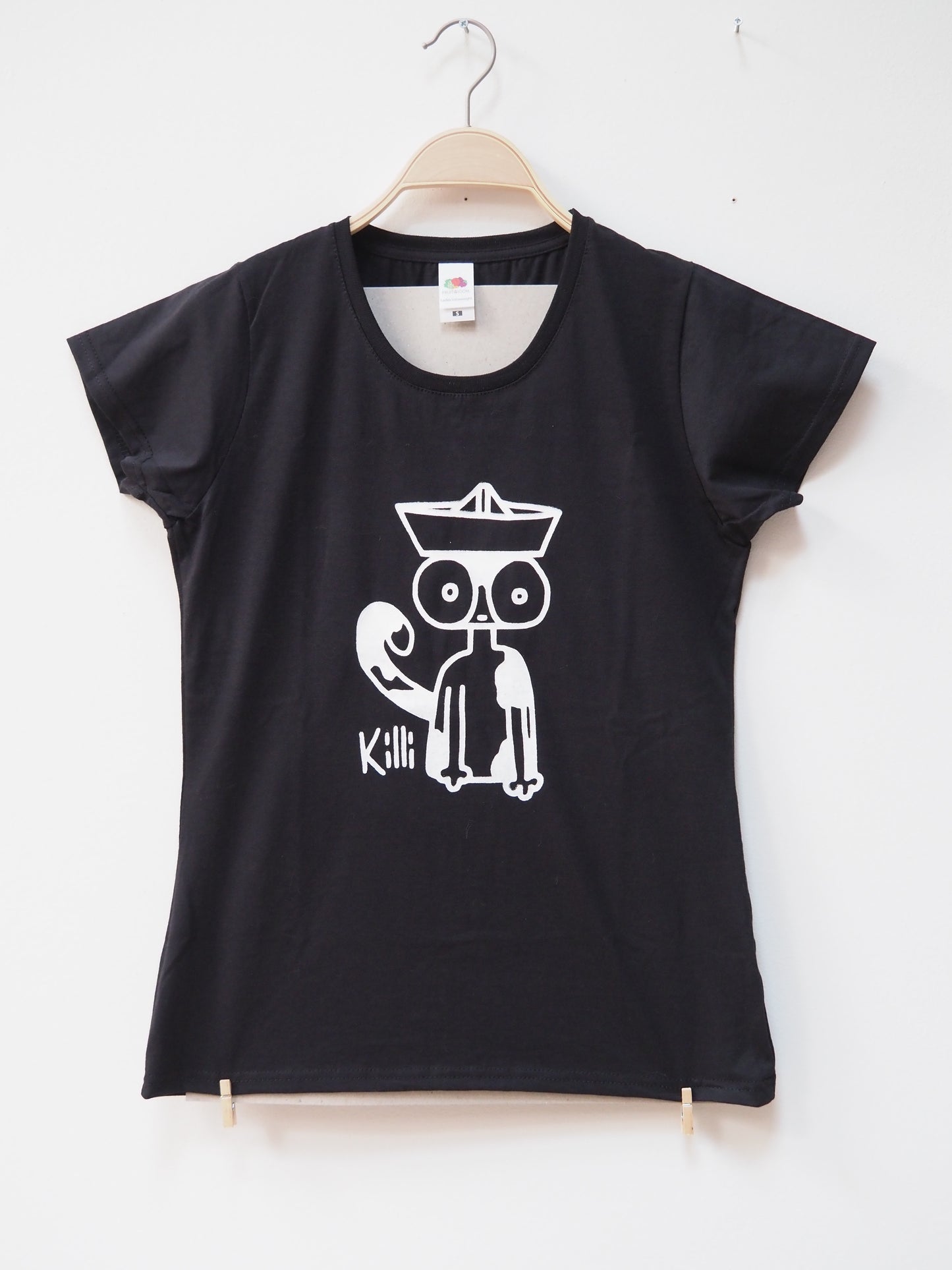 Black t-shirt with a white graphic design of a cat wearing a paper hat on a hanger against a white background