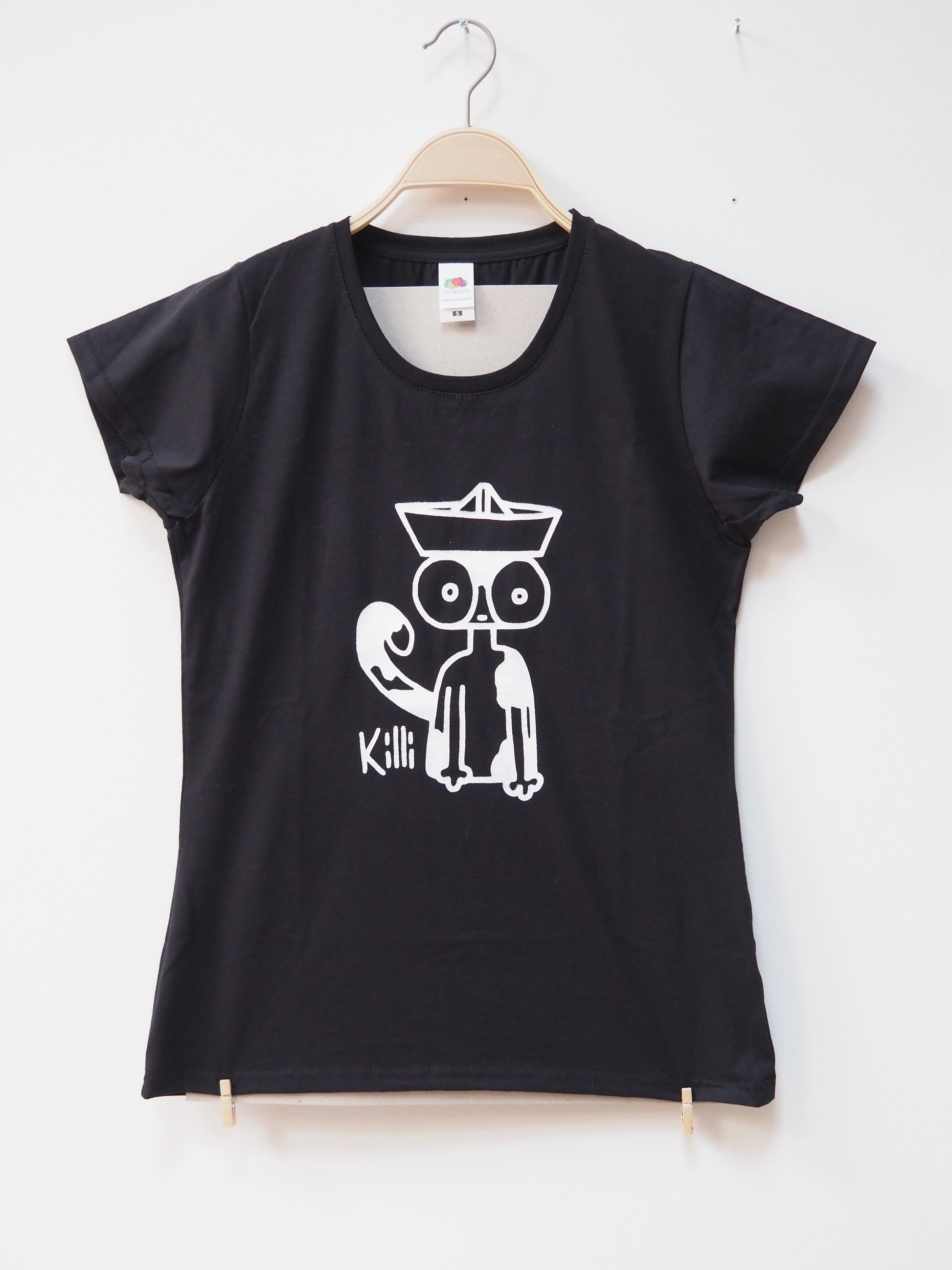 Black t-shirt with a white graphic design of a cat wearing a paper hat on a hanger against a white background