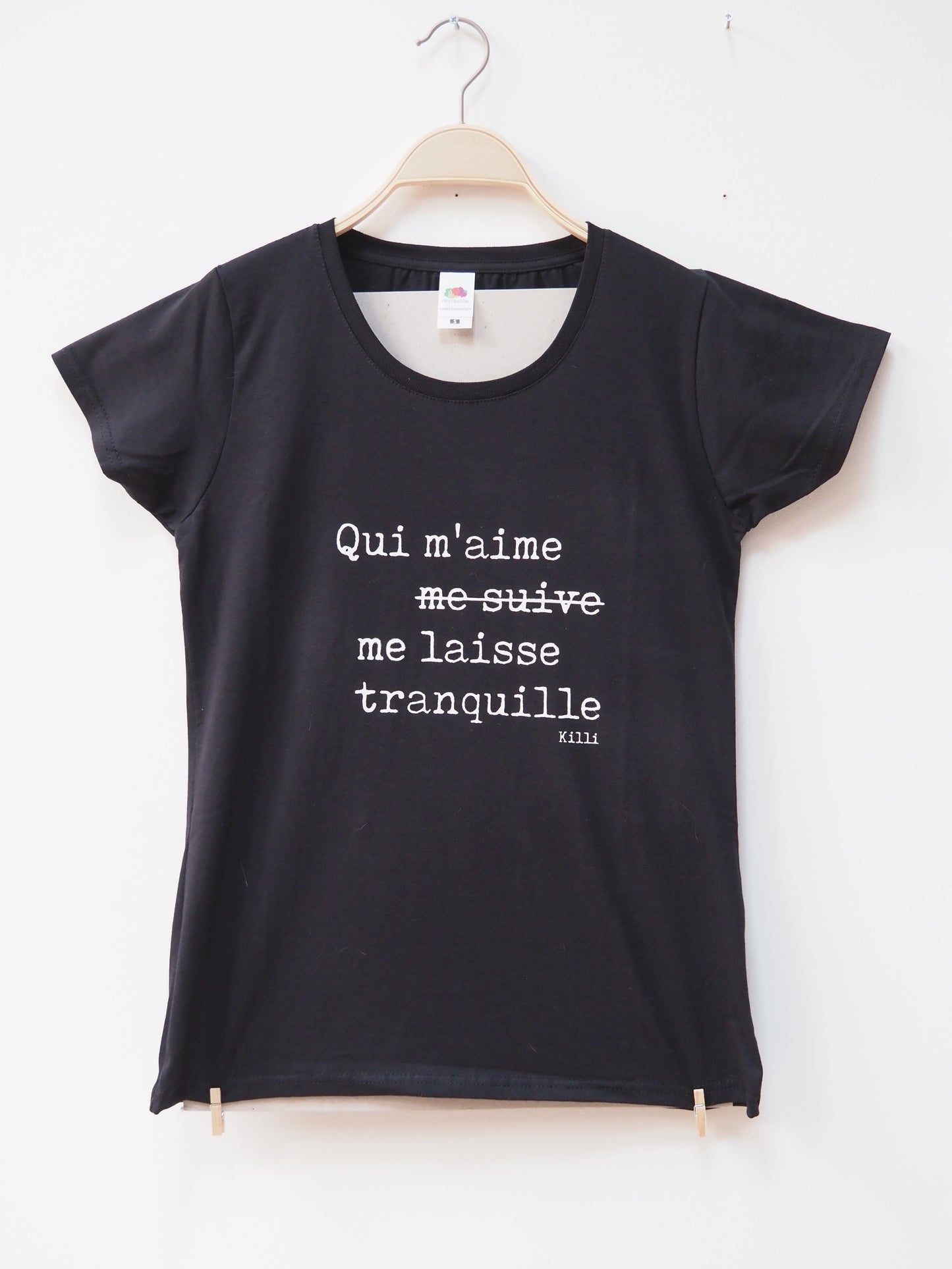 Black t-shirt with white text in french on a white background