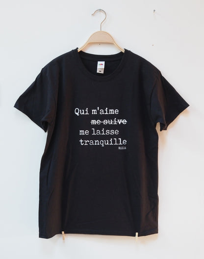 Black t-shirt with white text in french on a hanger against a white background